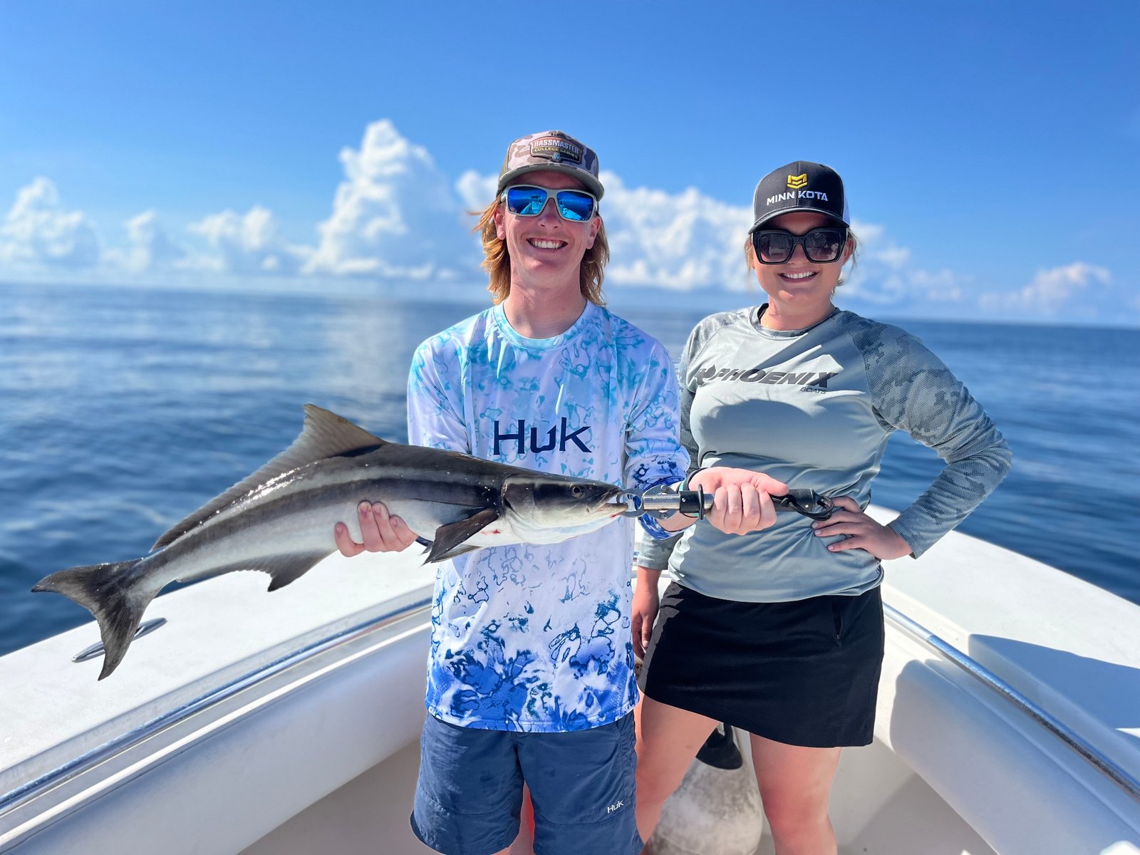 Smiling angler holding a cobia on a sunny day offshore with Marsh View Charters