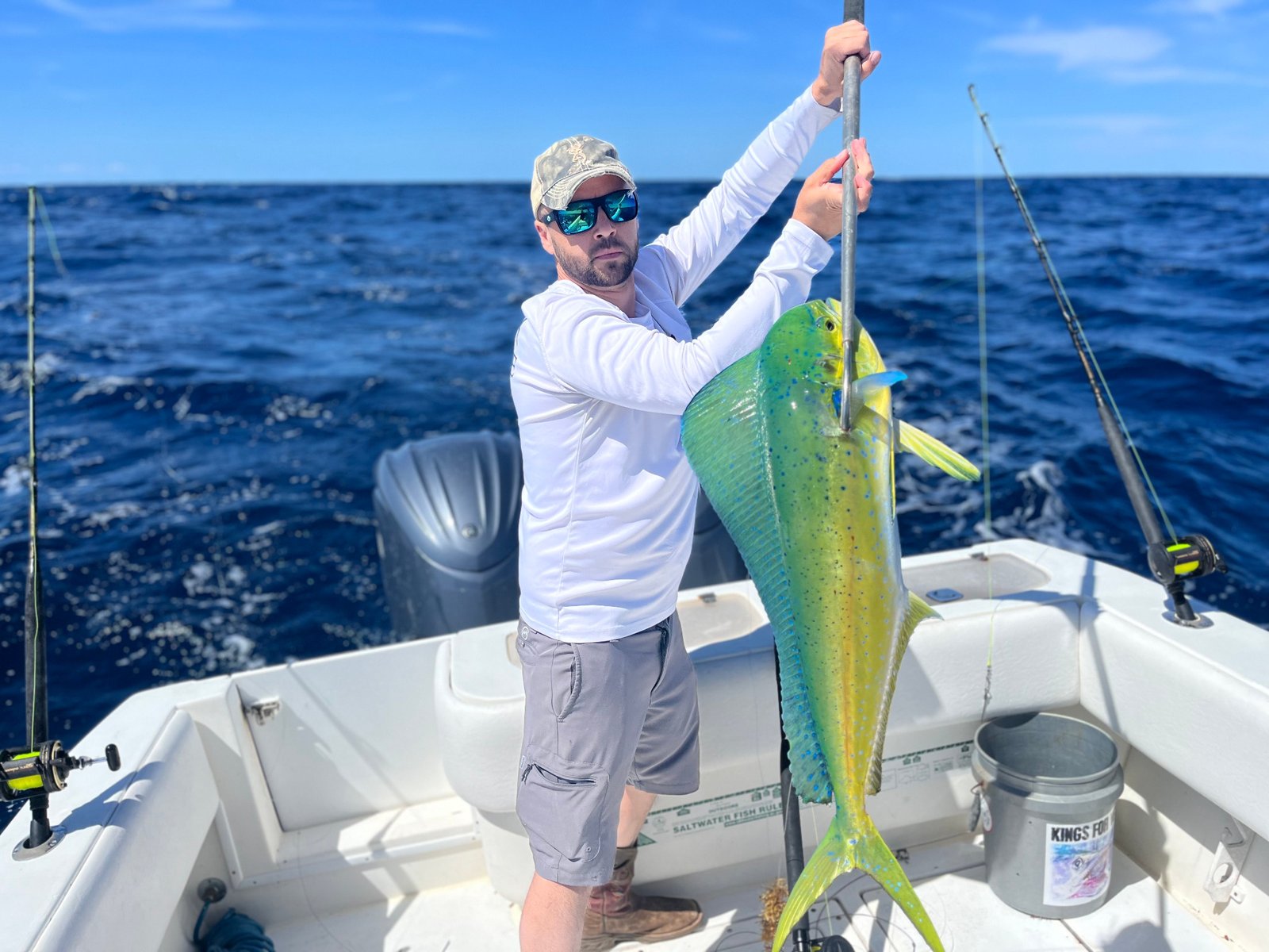 Angler hoisting a vibrant mahi mahi caught during a Charleston offshore trolling trip